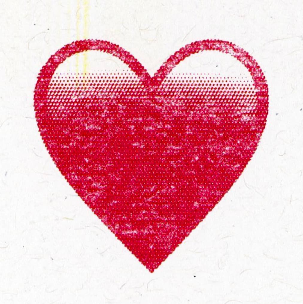 Macro view of a textured red heart, showcasing the intricacies and grains of the risograph printing method.